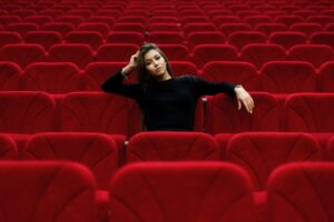 A woman sits in a theatre