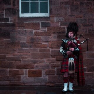 A man playing bagpipes in Edinburgh